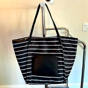 Black bag with white stripes. Magnetic clasp in the middle & sides of zipper.